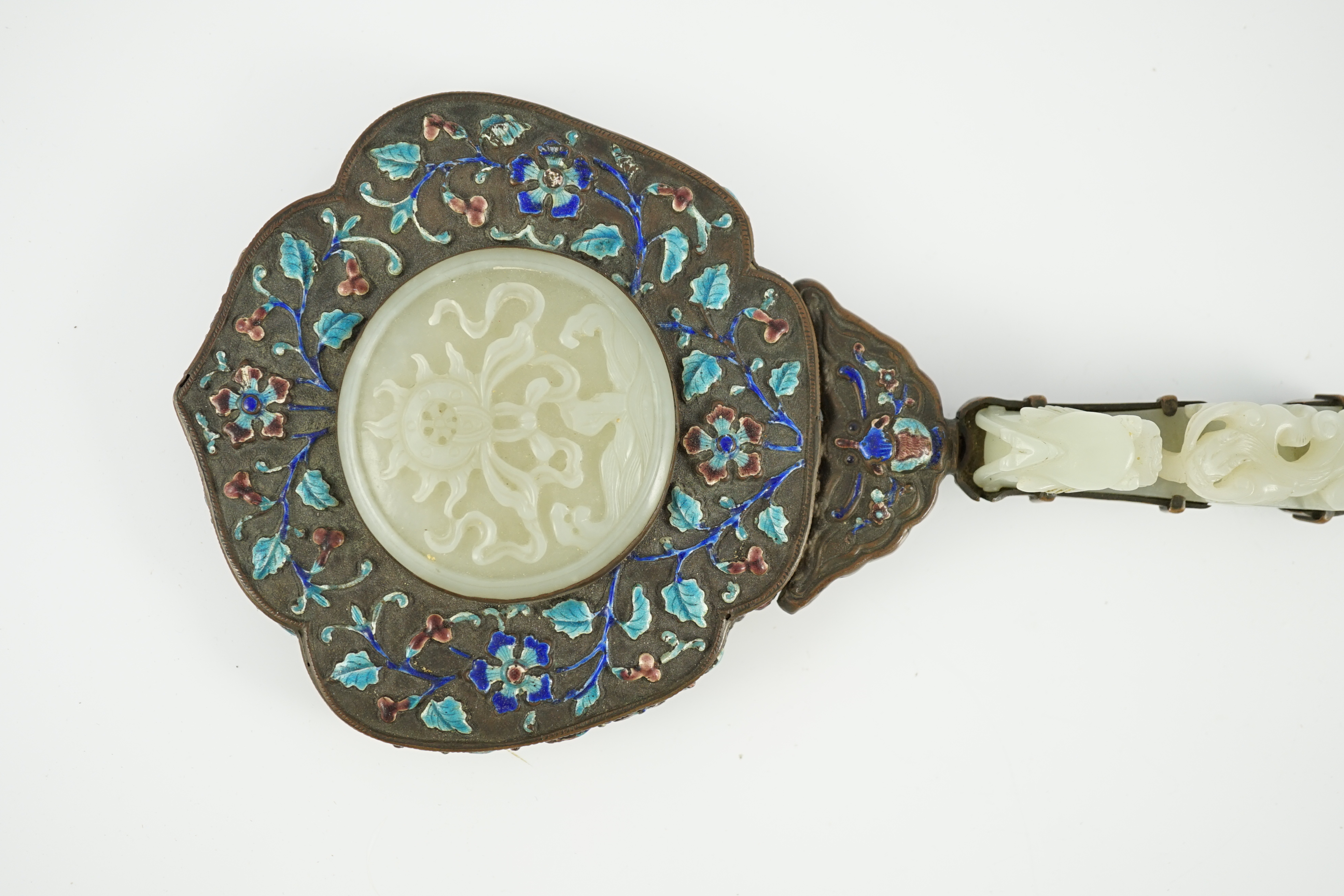 An early 20th century Chinese enamelled copper hand mirror with 18th/19th century Chinese pale celadon jade mounts